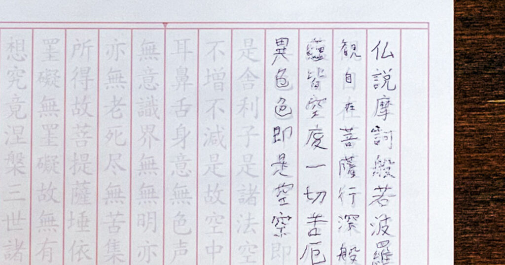 息子が途中まで書いた般若心経の写経用紙。1行目は大きく、2行目から急に文字が小さくなっている